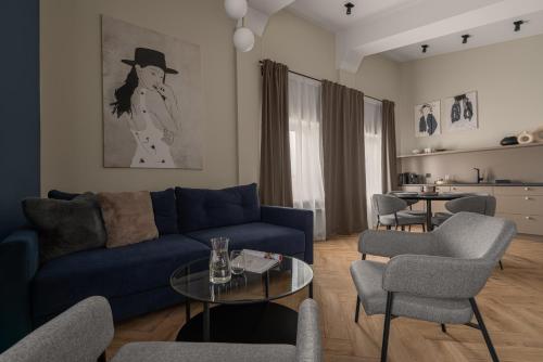a living room with a blue couch and chairs at APARTIO ROOMS Katowice in Katowice