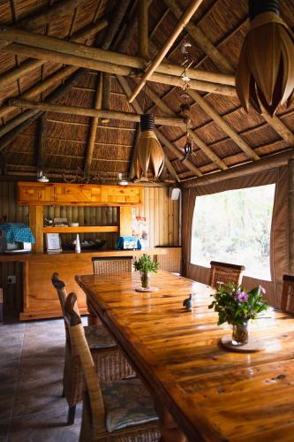 a dining room with a large wooden table and chairs at Khashamongo B & B in Somerset West