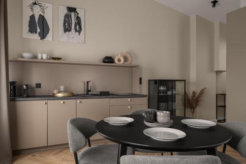 a dining room with a table and chairs and a kitchen at APARTIO ROOMS Katowice in Katowice