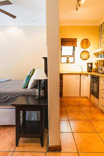 a kitchen and a bedroom with a table and a bed at Khashamongo B & B in Somerset West
