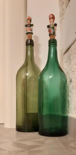 two green glass bottles sitting on top of a floor at Pietra d'angolo in Locorotondo