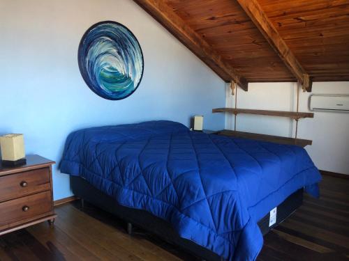 1 cama con edredón azul en una habitación en El Mirador, en Punta del Diablo