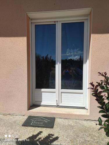 a sliding glass door with a sign in front of it at L'annexe du font Blanque in Campsas