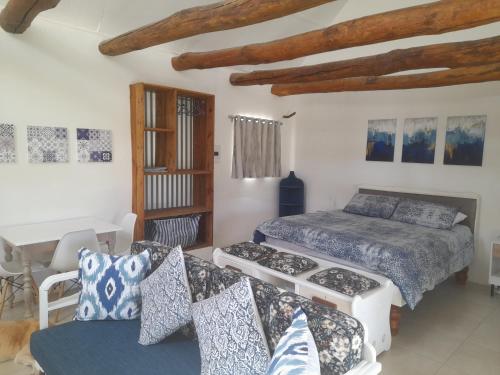 a bedroom with a bed and a couch and a table at Die Hoenderhok and Die Plaashuisie in Swellendam