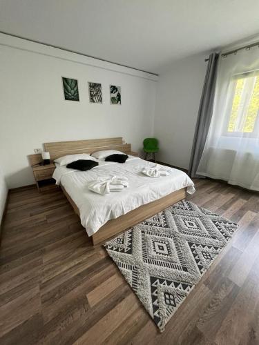 a bedroom with a large bed and a rug at Pensiunea Broscuta in Horezu