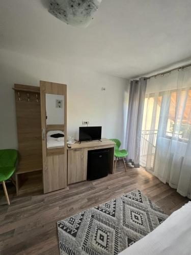 a bedroom with a desk with a laptop on it at Pensiunea Broscuta in Horezu