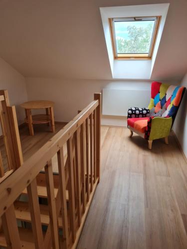 a room with a staircase and a chair and a window at Chata Eliška Hrdlička, Čím u Prahy in Čím