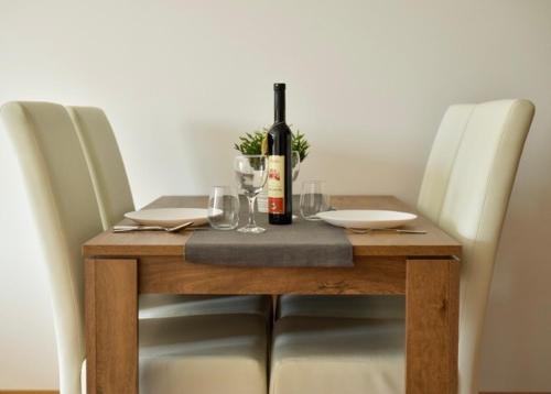 a wooden table with a bottle of wine on it at Sofija in Ulcinj