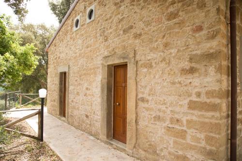 a brick building with a wooden door on it at Villa Ginevra Resort Agrituristico in Ficarra