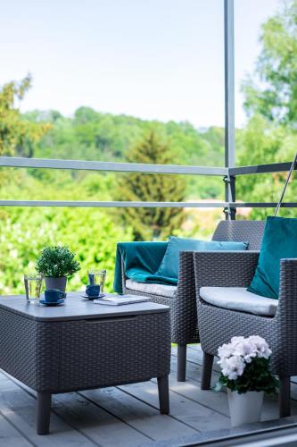 a patio with wicker chairs and a table on a balcony at Apartamenty Wczasowa - z widokiem na góry, parkingiem, rowerownią in Kudowa-Zdrój