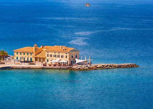 a large building on a island in the water at Andri House in Marathias
