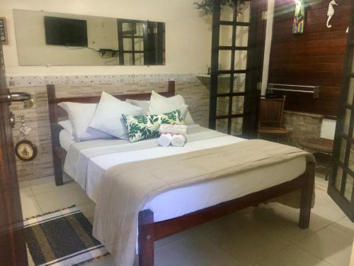 a bedroom with a bed with two stuffed animals on it at Pousada Refugio do Pirata in Trindade