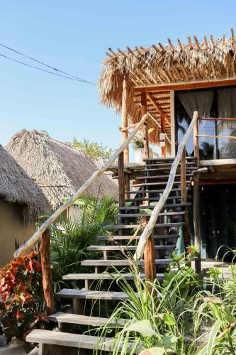 a staircase leading to a house with a thatch roof at Casa Mate BeachFront Cabañas El Cuyo in El Cuyo