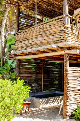 a wooden building with a bench in front of it at Casa Mate BeachFront Cabañas El Cuyo in El Cuyo