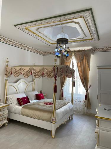 a bedroom with a canopy bed with a fancy ceiling at Chambre Orientale Chérazade Maison de L'Église in Narbonne