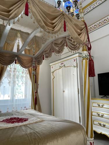 a bedroom with a canopy bed and a television at Chambre Orientale Chérazade Maison de L'Église in Narbonne