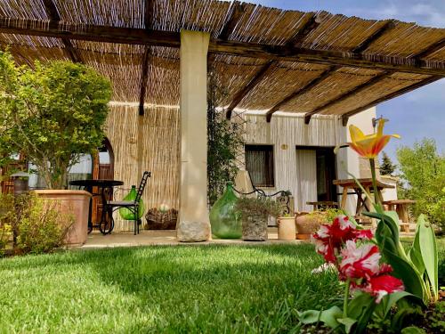 a pergola in a garden with a grass yard at Masseria Casina Montana in Corigliano dʼOtranto
