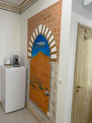 a painting of an archway in a room with a refrigerator at Chambre Orientale Chérazade Maison de L'Église in Narbonne