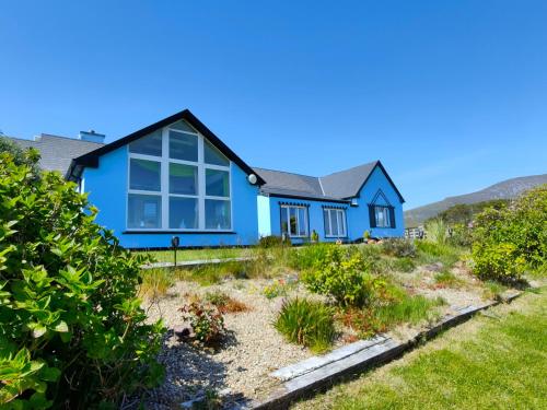 ein blaues Haus auf einem Hügel mit Garten in der Unterkunft Ferndale Luxury Boutique Bed & Breakfast in Keel
