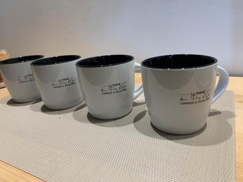 four coffee cups sitting on top of a table at La Ferme du Puy d'Or in Limonest