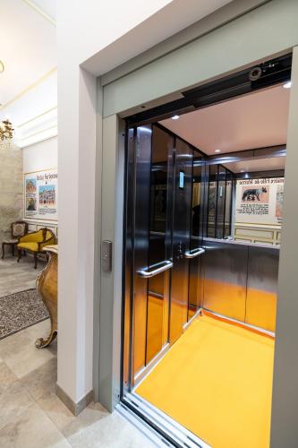 a glass door in a building with a yellow floor at Chambre Orientale Chérazade Maison de L'Église in Narbonne