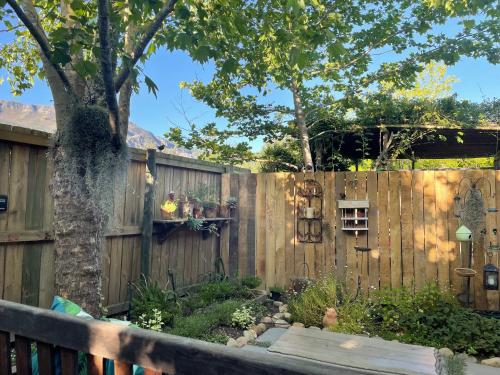 a fence with a tree in a yard at French Kisses in Greyton