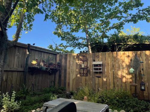 a wooden fence with a wooden table in a yard at French Kisses in Greyton