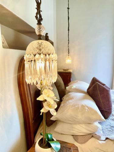 a lamp on a table next to a bed at French Kisses in Greyton