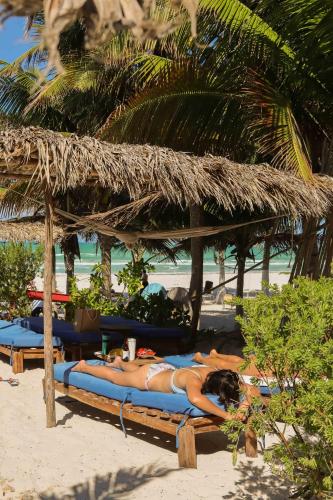 a group of people laying on the beach at Casa Mate BeachFront Cabañas El Cuyo in El Cuyo