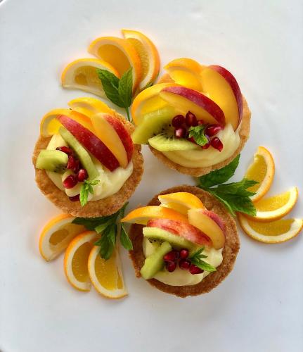 four appetizers with fruit and vegetables on a white plate at Masseria Casina Montana in Corigliano dʼOtranto