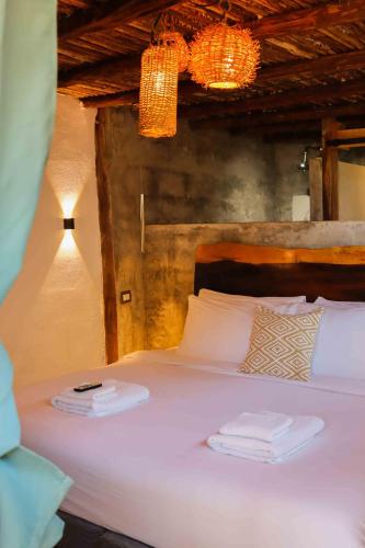 a bedroom with a bed with two towels on it at Casa Mate BeachFront Cabañas El Cuyo in El Cuyo
