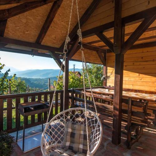 a porch swing hanging from a wooden roof at Brvnara na bregu in Bajina Bašta