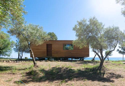 mały drewniany dom na wzgórzu z drzewami w obiekcie iHouse Nea Skioni w Nea Skioni