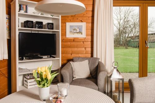 a living room with a tv and a table and chairs at Kastanienhof in Kalleby