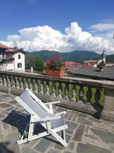 a white chair sitting on a balcony with a view at Residenza Santa Valeria in Caglio