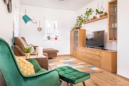 a living room with a green chair and a television at Ferienhaus Schlagerbauer Biohof in Salzburg