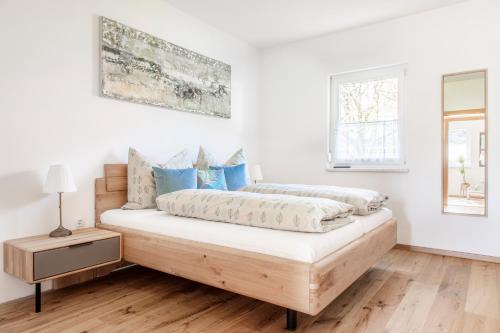 Dormitorio blanco con cama con almohadas azules en Ferienhaus Schlagerbauer Biohof en Salzburgo