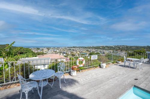 a patio with a table and chairs on a deck at The Lookout Guest House in Port Alfred