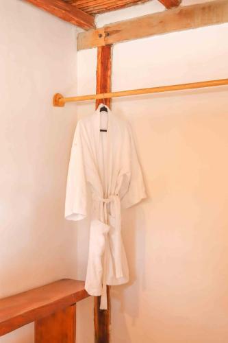 a white robe is hanging on a wall at Casa Mate BeachFront Cabañas El Cuyo in El Cuyo