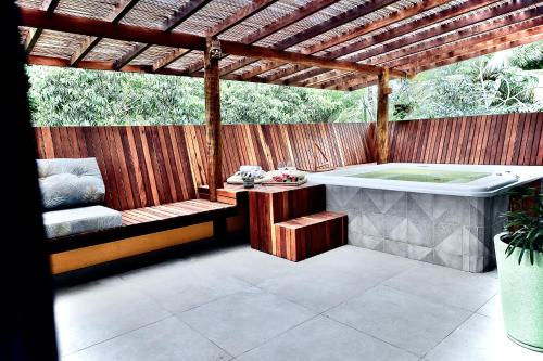 a hot tub sitting under a wooden pergola at HaraMatha in Barra Grande