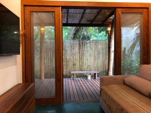 a living room with a sliding glass door with a bench at HaraMatha in Barra Grande