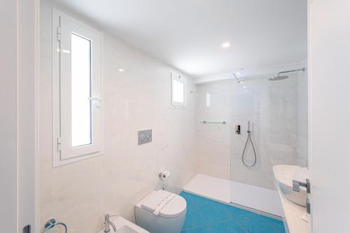 a white bathroom with a shower and a toilet at Grand Hotel Le Rocce in Gaeta