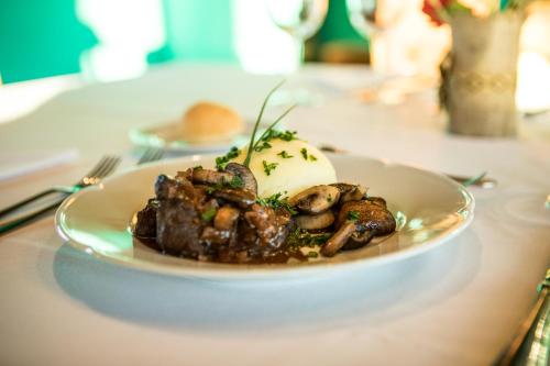 a plate of food with mushrooms on a table at Lago Rosario Lodge in Trevelin