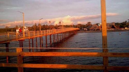 a bridge over the water with people walking on it at Gran Muelle Hotel in San Bernardo del Viento