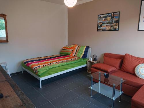 un soggiorno con letto e divano di FeWo Leipziger Neuseenland a Neukieritzsch