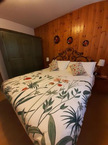 a bedroom with a large bed with a floral bedspread at Sella Ronda Apartment in Campitello di Fassa