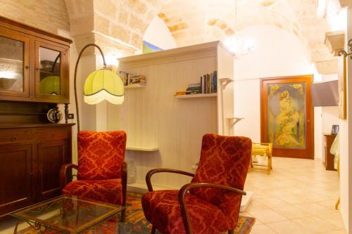 a living room with two chairs and a glass table at Villa Tonia in Fasano