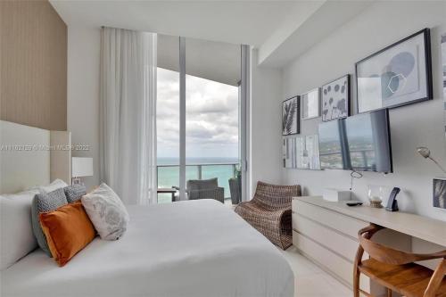 a bedroom with a bed and a desk with a view at Penthouse Condo at Lyfe Resort and Residences in Hollywood