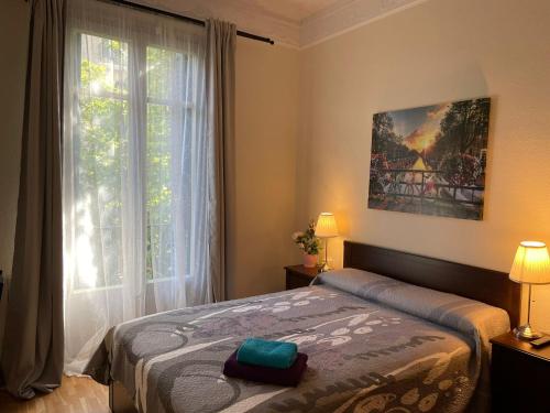 1 dormitorio con cama y ventana grande en Rooms Aribau en Barcelona
