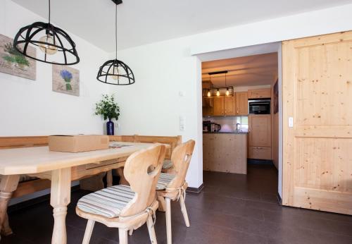 a kitchen and dining room with a wooden table and chairs at Apartments Drei Türme by Pferd auf Wolke in Schruns-Tschagguns